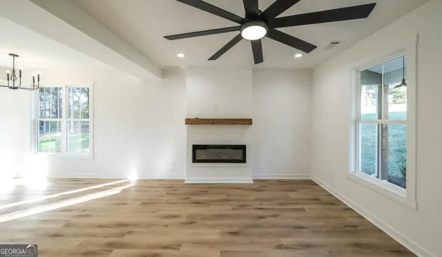 an empty room with windows and ceiling fan