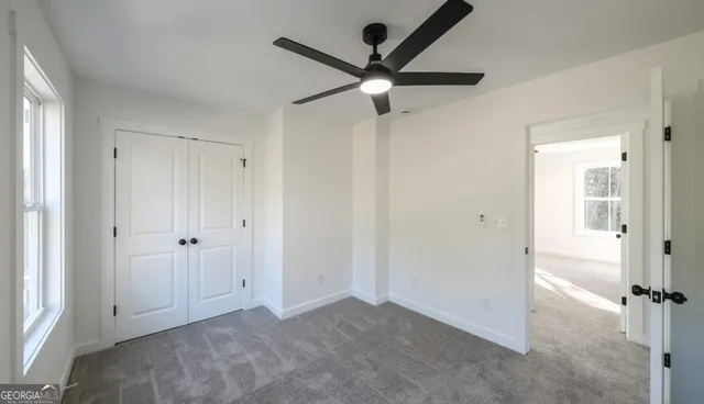 a view of a livingroom with a ceiling fan & a ceiling fan
