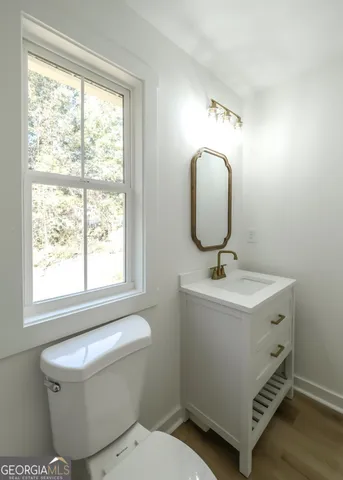 a bathroom with a toilet sink and mirror