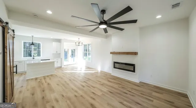 a living room with stainless steel appliances wooden floor and a fireplace