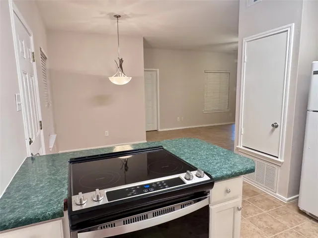 a kitchen with granite countertop a stove and a shower
