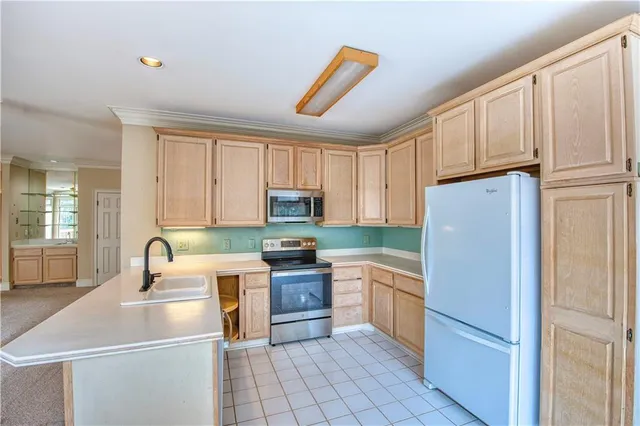 a kitchen with cabinets appliances a sink and a window