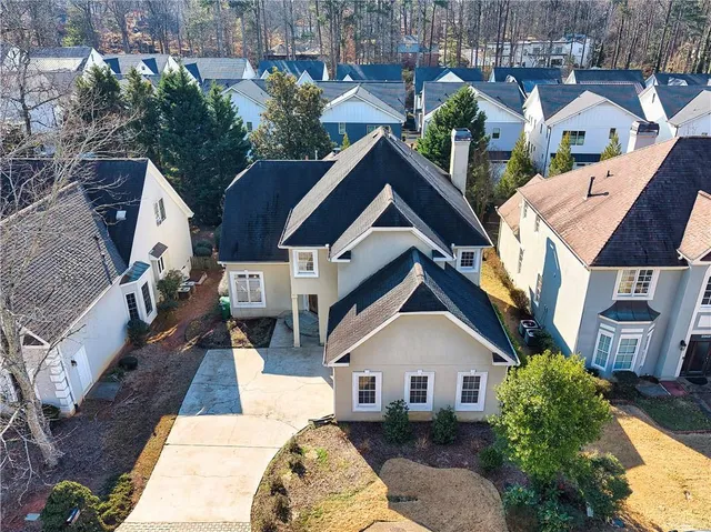 an aerial view of a house with yard and patio