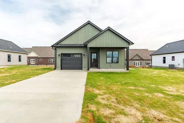 a front view of a house with a garden and yard