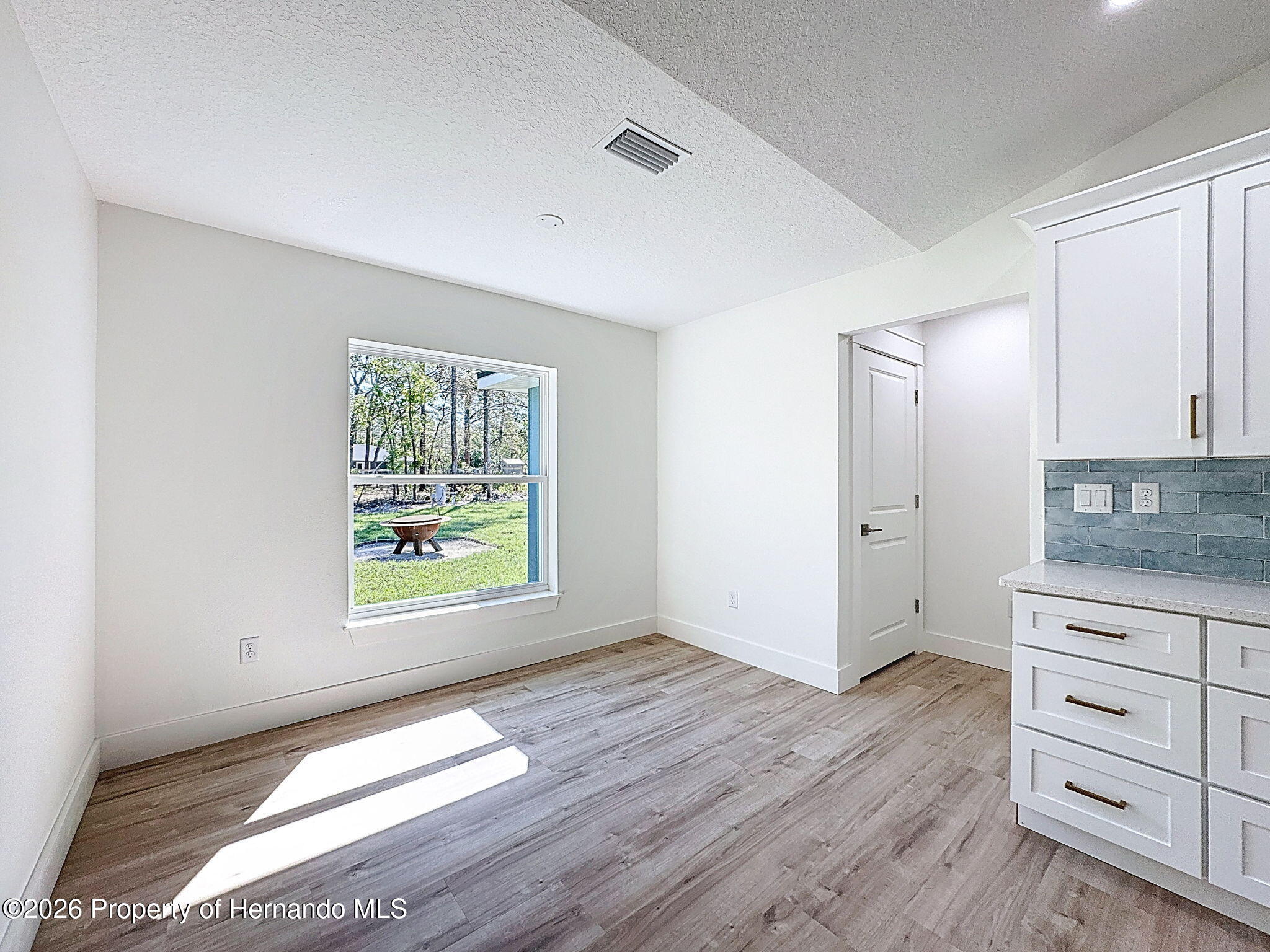 8988 Waterbird Way Weeki Wachee, FL 34613 - Photo 21 of 42 wooden floor in an empty room with a window