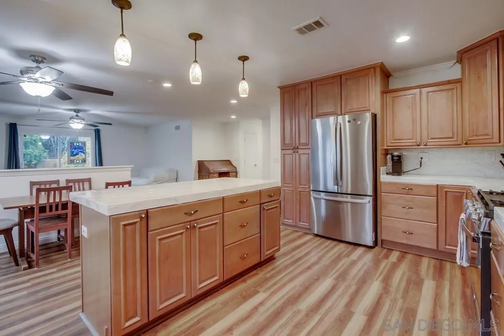 10520 El Nopal Santee, CA 92071 - Photo 4 of 34 a kitchen with a refrigerator a sink and dishwasher with wooden floor
