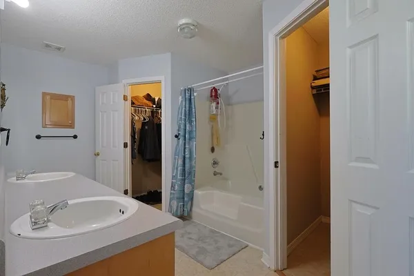 a bathroom with a tub sink shower and mirror