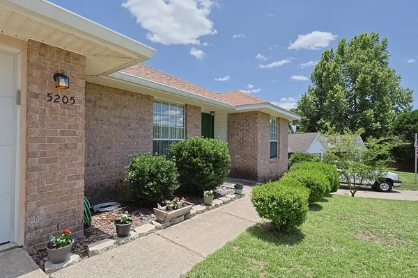 a front view of a house with a yard and potted plants