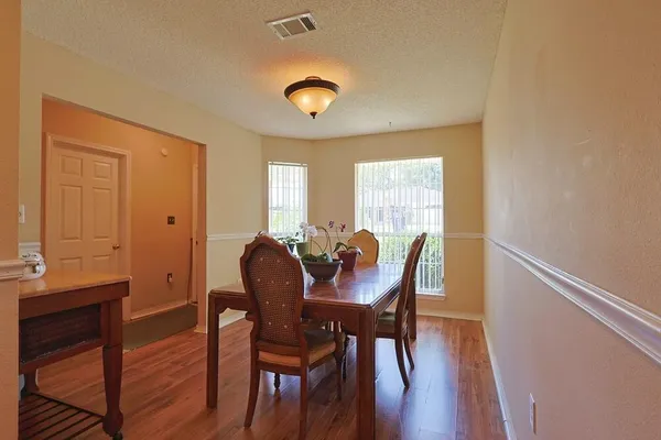 a view of a a dining room with furniture window and wooden floor