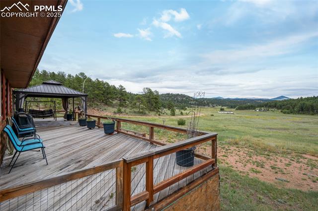 608 Slater Creek Road Guffey, CO 80820 - Photo 19 of 47 Wooden terrace with a gazebo, a rural view, a mountain view, and a lawn