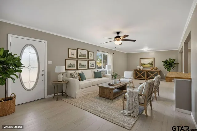 a living room with furniture a chandelier a fireplace and a potted plant