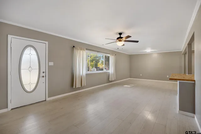 an empty room with windows and fan