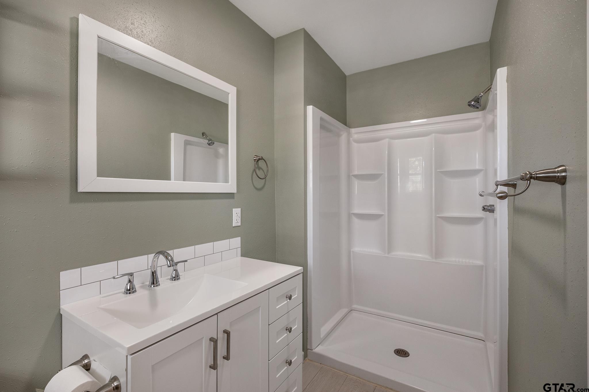 291 East Main Street Van, TX 75790 - Photo 26 of 43 a bathroom with a shower sink vanity and mirror