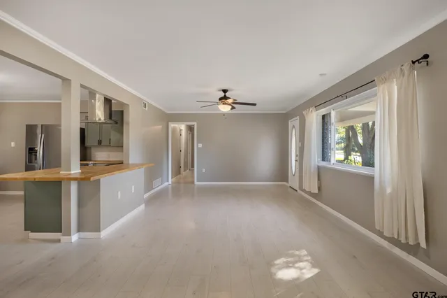 a view of an empty room with window and cabinet