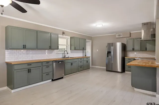 a large kitchen with a sink and stainless steel appliances