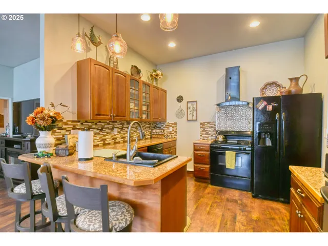 a kitchen with stainless steel appliances kitchen island granite countertop a table and chairs in it