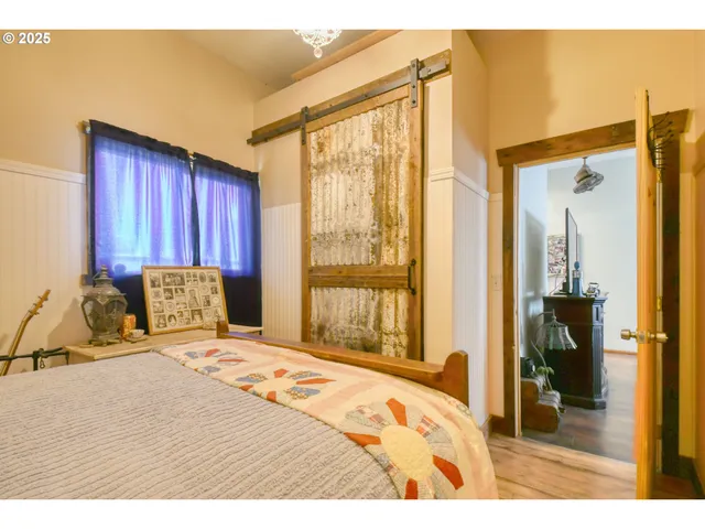 a bedroom with a bed and large windows