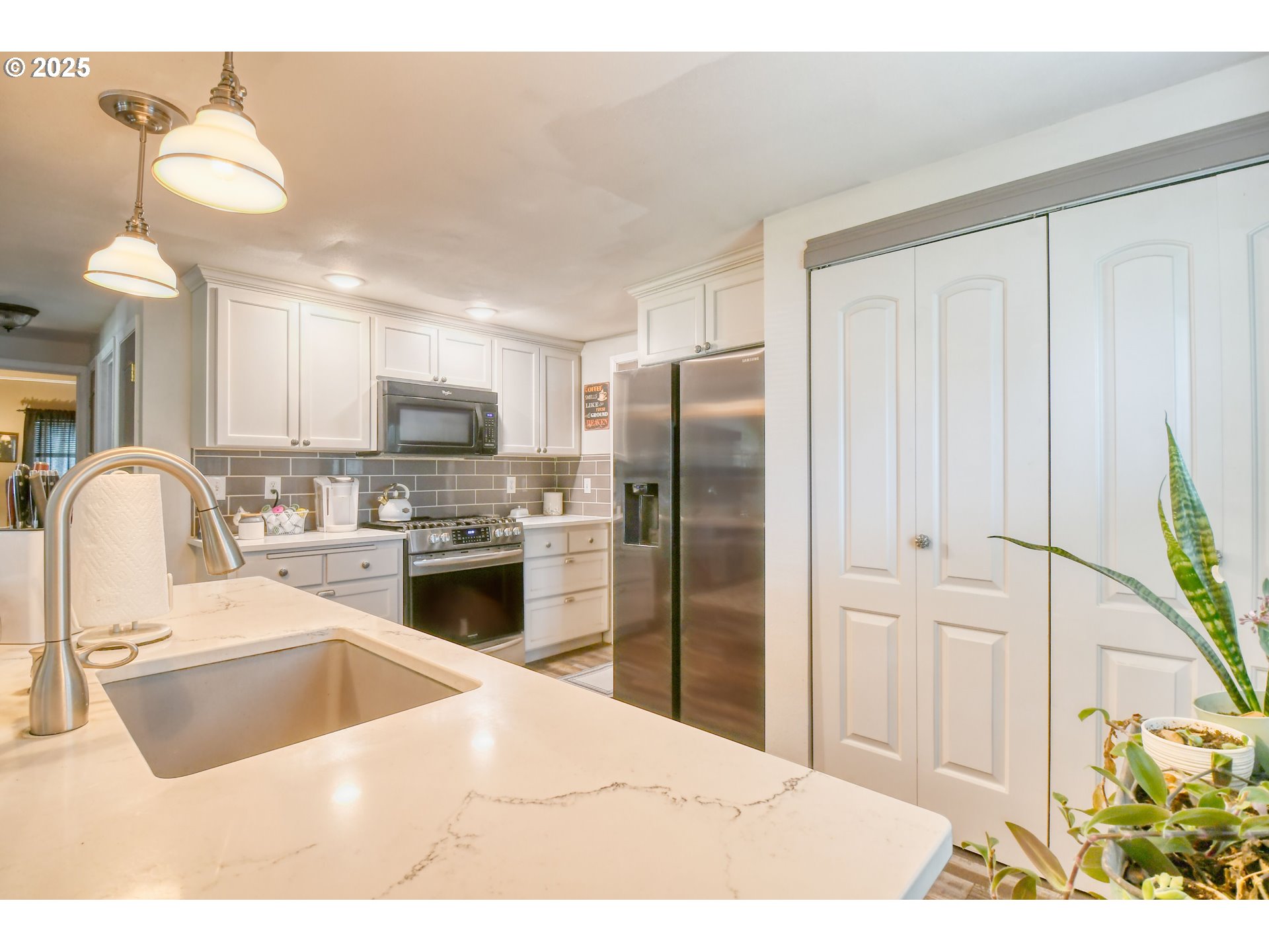 330 2nd Street Athena, OR 97813 - Photo 7 of 30 a kitchen with stainless steel appliances kitchen island granite countertop a refrigerator a sink a stove with white cabinets
