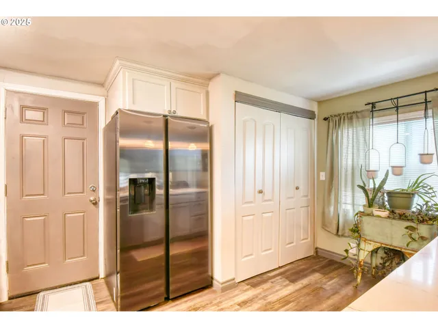 a living room with stainless steel appliances kitchen island granite countertop a refrigerator and cabinets