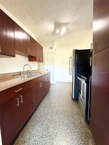 a kitchen with stainless steel appliances granite countertop a refrigerator and a sink