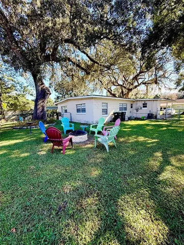 a view of a backyard with table and chairs and a fire pit