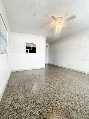 an empty room with a ceiling fan and bathroom