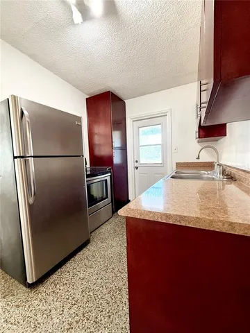 a kitchen with kitchen island a counter top space cabinets and stainless steel appliances