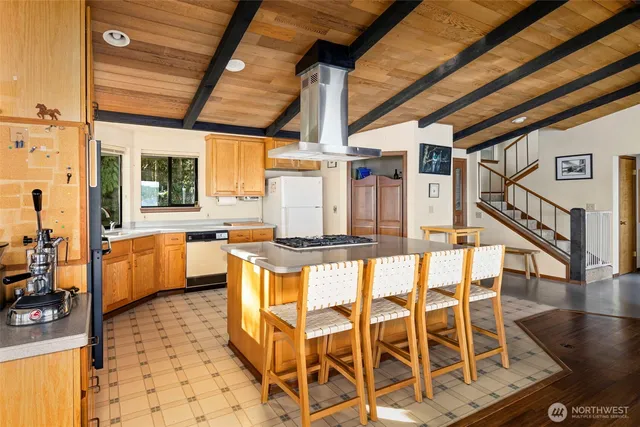 a dining hall with stainless steel appliances granite countertop a stove a refrigerator a fireplace with a dining table and chairs