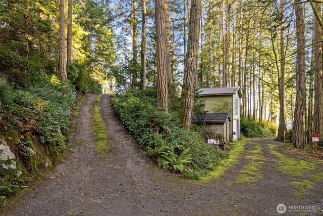a small barn with a table and chairs in front of it