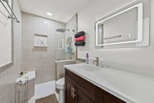 a bathroom with a sink vanity mirror and toilet