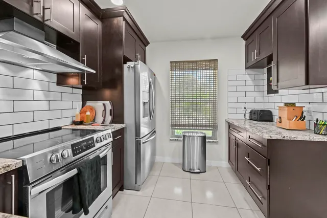 a kitchen with stainless steel appliances granite countertop a stove and a refrigerator