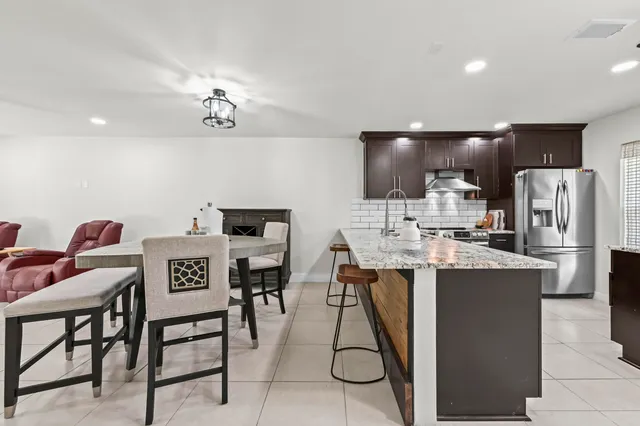 a dining room with stainless steel appliances kitchen island a table and chairs