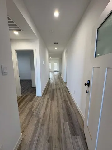 a view of a hallway with wooden floor