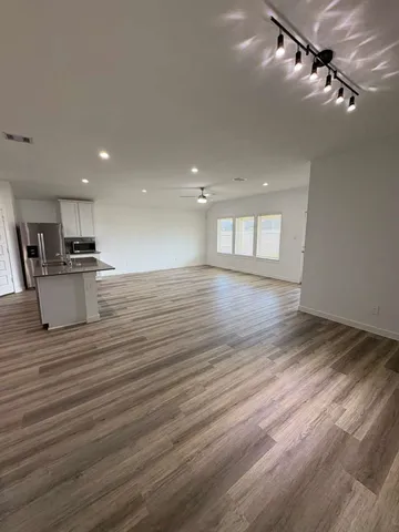 a view of empty room with wooden floor