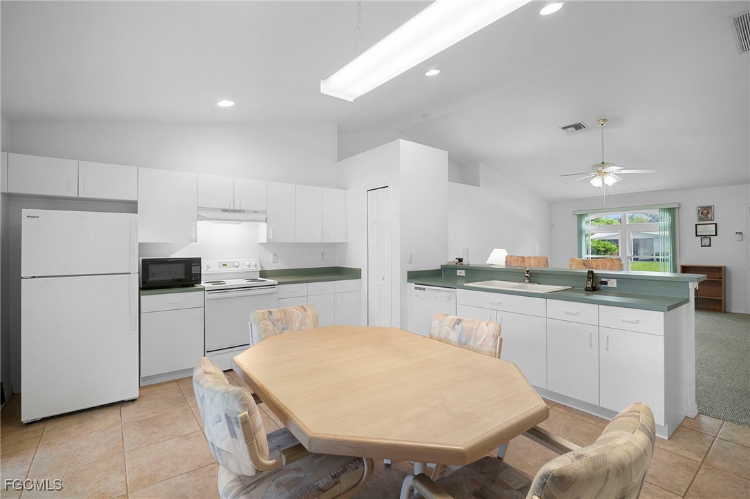 2932 Holly Road Fort Myers, FL 33901 - Photo 12 of 39 a kitchen with a white cabinets and chairs