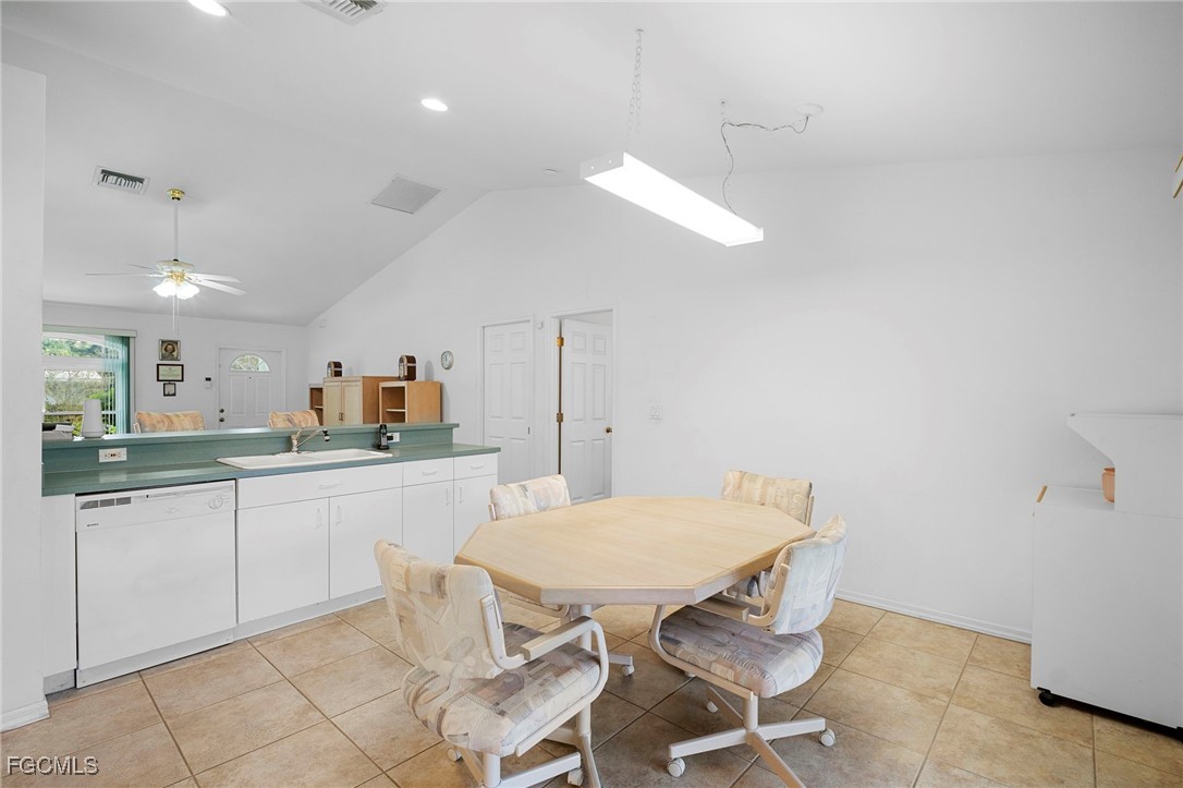 2932 Holly Road Fort Myers, FL 33901 - Photo 13 of 39 a kitchen with a dining table chairs and white cabinets