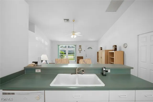 a kitchen with granite countertop white cabinets and stainless steel appliances
