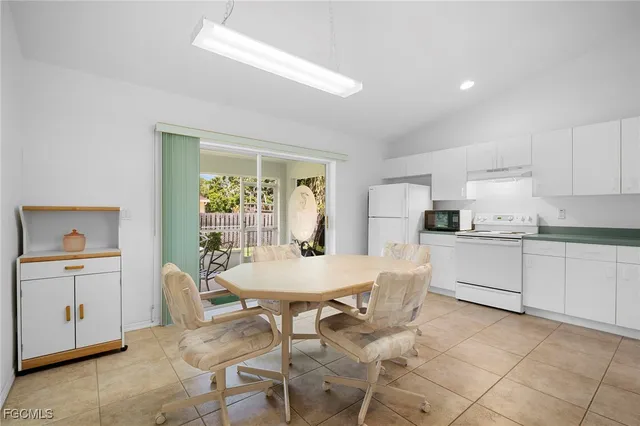 a kitchen with a sink dishwasher and white cabinets with wooden floor