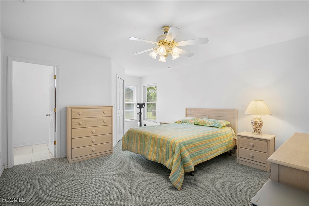 2932 Holly Road Fort Myers, FL 33901 - Photo 24 of 39 a bedroom with a bed and a chandelier