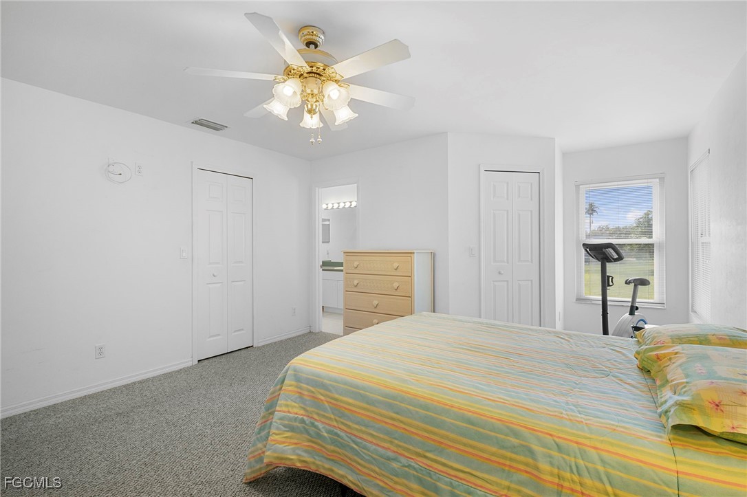 2932 Holly Road Fort Myers, FL 33901 - Photo 25 of 39 a bedroom with a bed and a chandelier