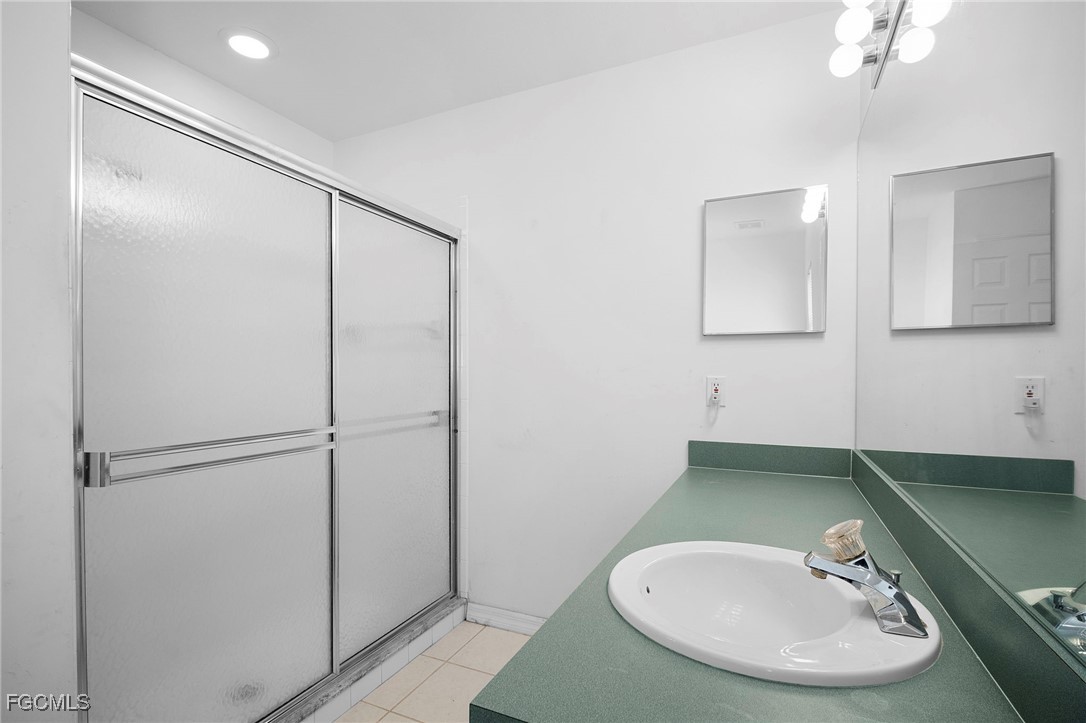 2932 Holly Road Fort Myers, FL 33901 - Photo 27 of 39 a bathroom with a sink and a mirror