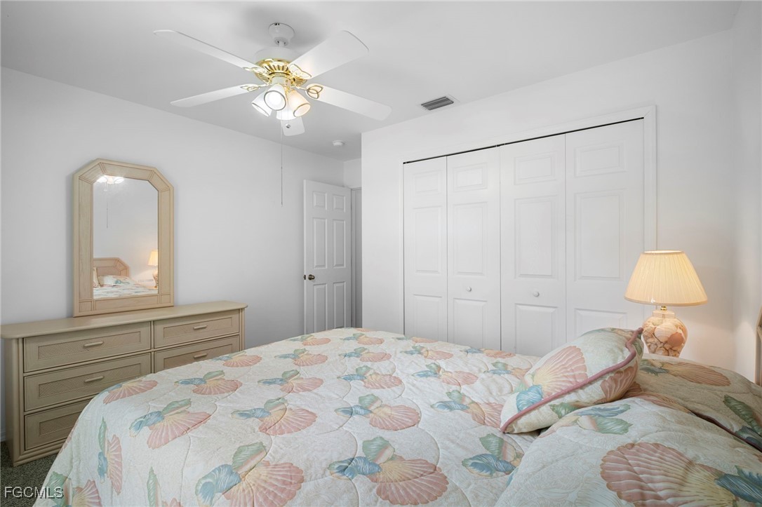 2932 Holly Road Fort Myers, FL 33901 - Photo 28 of 39 a bedroom with a bed and a chandelier