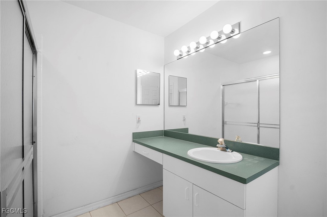 2932 Holly Road Fort Myers, FL 33901 - Photo 33 of 39 a bathroom with a sink and a mirror