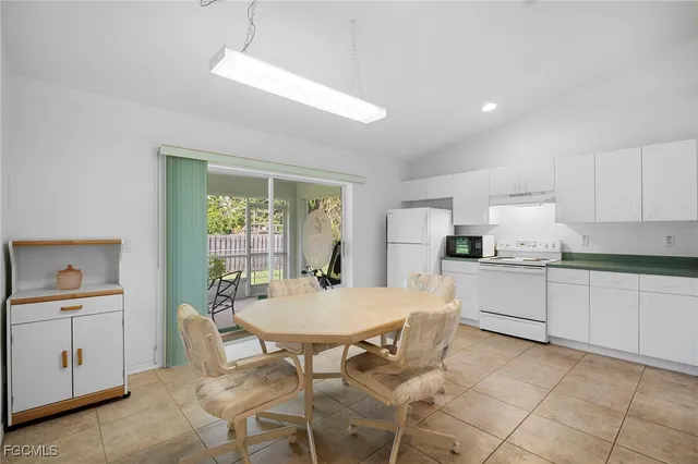 a kitchen with a dining table chairs and white cabinets