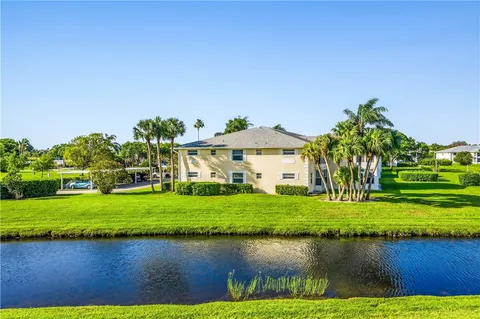 a front view of a house with a yard and lake view