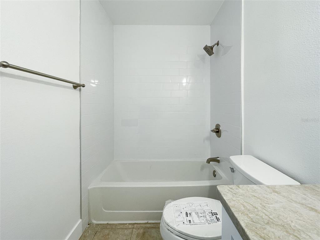 1400 Gandy Boulevard North, Unit 412 St. Petersburg, FL 33702 - Photo 22 of 44 a bathroom with a granite countertop bathtub sink vanity and toilet