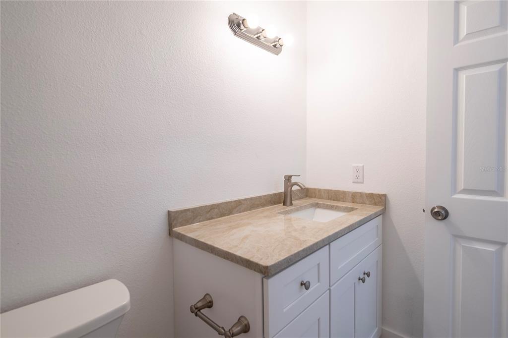 1400 Gandy Boulevard North, Unit 412 St. Petersburg, FL 33702 - Photo 23 of 44 a bathroom with a granite countertop sink and a toilet