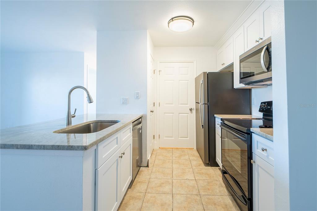 1400 Gandy Boulevard North, Unit 412 St. Petersburg, FL 33702 - Photo 7 of 44 a kitchen with stainless steel appliances granite countertop a refrigerator sink and stove
