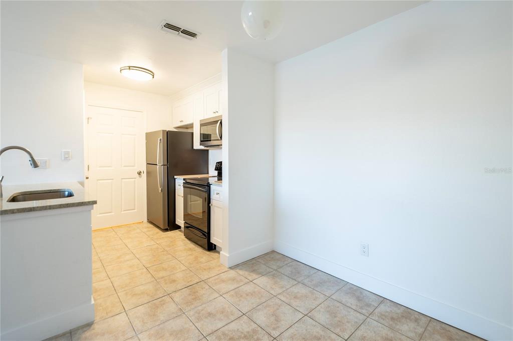 1400 Gandy Boulevard North, Unit 412 St. Petersburg, FL 33702 - Photo 8 of 44 a kitchen with refrigerator and microwave