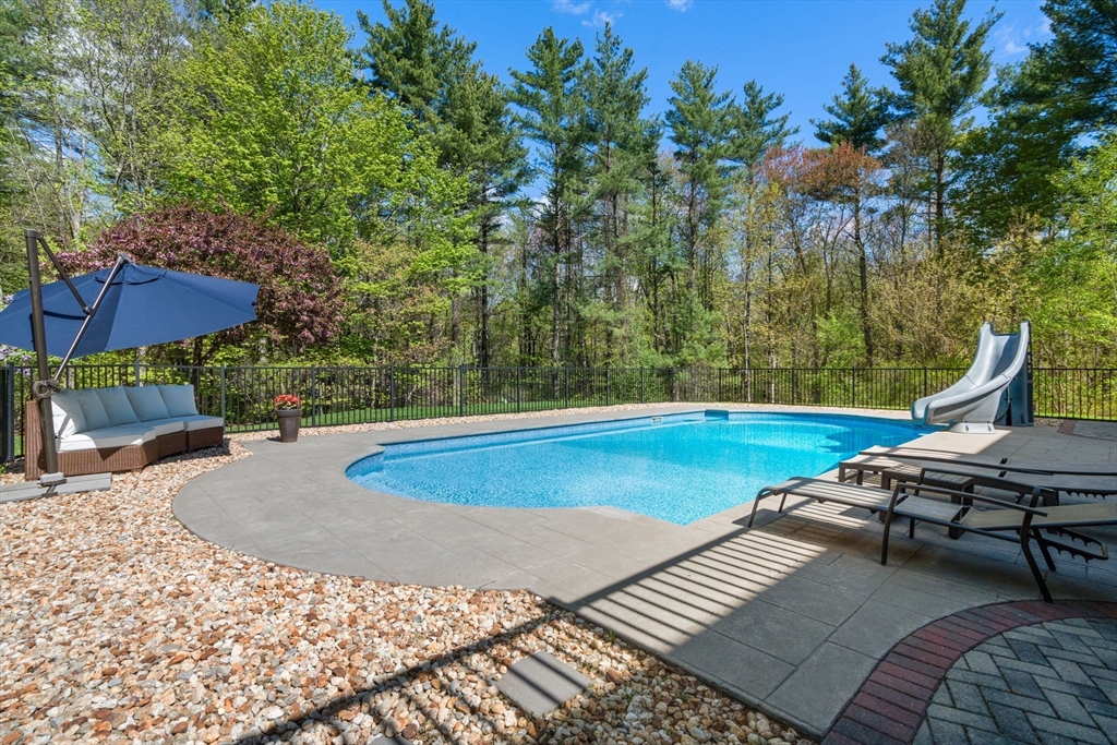 220 Newtown Road Acton, MA 01720 - Photo 33 of 39 a view of a swimming pool with a lounge chair and trees around